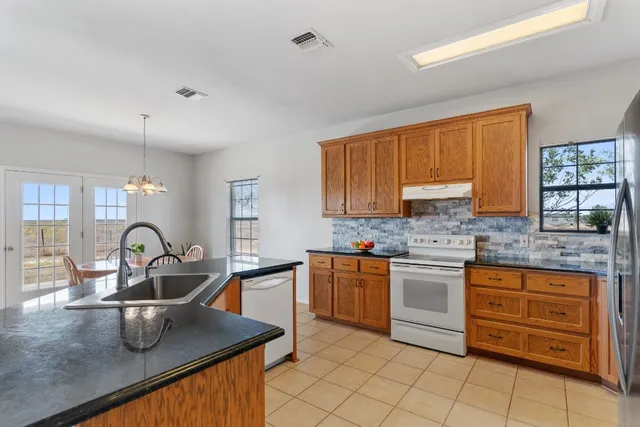 a kitchen with kitchen island granite countertop a sink stove and cabinets