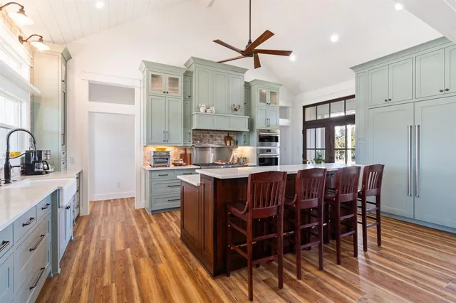 a kitchen with a table chairs refrigerator and microwave