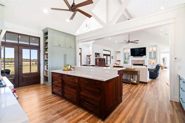 a large kitchen with stainless steel appliances granite countertop a lot of counter space and a wooden floors