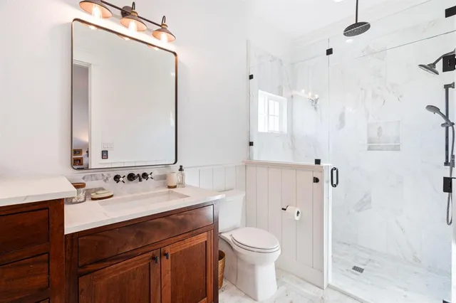 a bathroom with a sink a toilet and shower