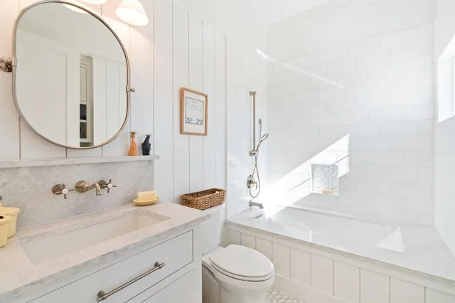 a bathroom with a sink a toilet and a mirror