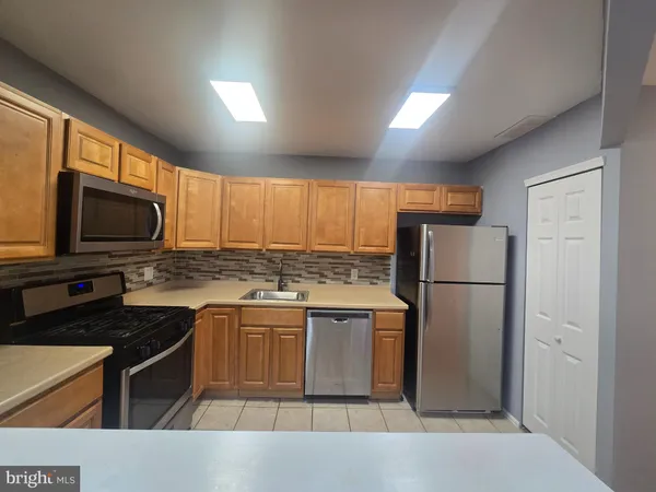 a kitchen with a refrigerator a microwave a sink and cabinets