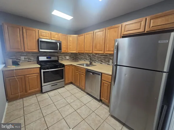 a kitchen with stainless steel appliances granite countertop a refrigerator stove a sink and a microwave