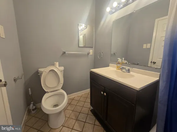 a bathroom with a toilet sink vanity and mirror