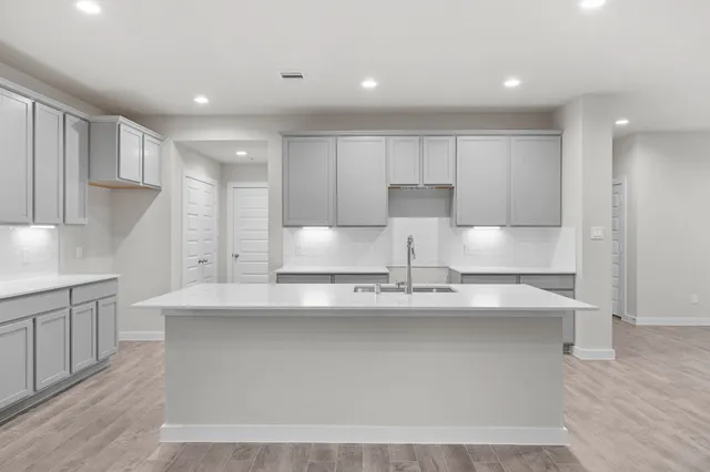 a large kitchen with stainless steel appliances granite countertop a sink a stove and a refrigerator