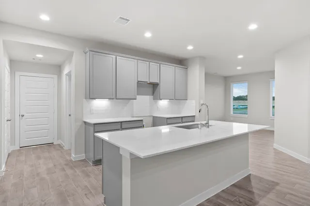 a large kitchen with kitchen island a sink stainless steel appliances and cabinets