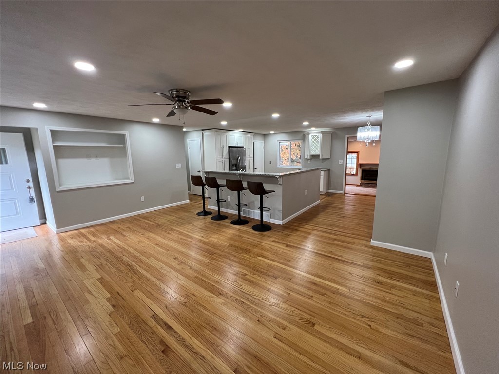 5105 Hillside Road Independence, OH 44131 - Photo 12 of 35 Living room featuring built in shelves, ceiling fan with notable chandelier, and light hardwood / wood-style flooring