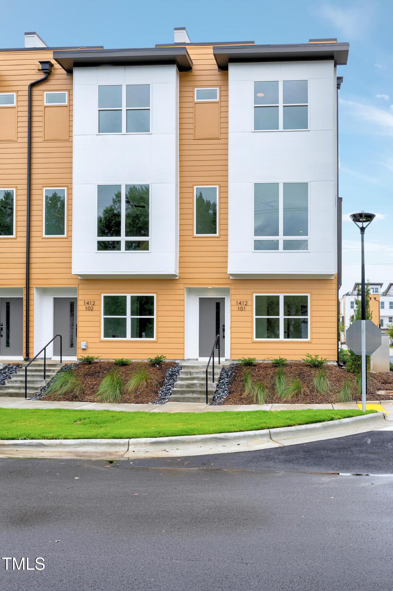 1412 Sawyer Road, Unit 101 Raleigh, NC 27610 - Photo 1 of 33 a front view of a house with a yard and garage