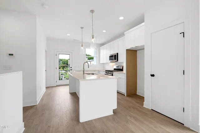 a kitchen with kitchen island white cabinets and stainless steel appliances