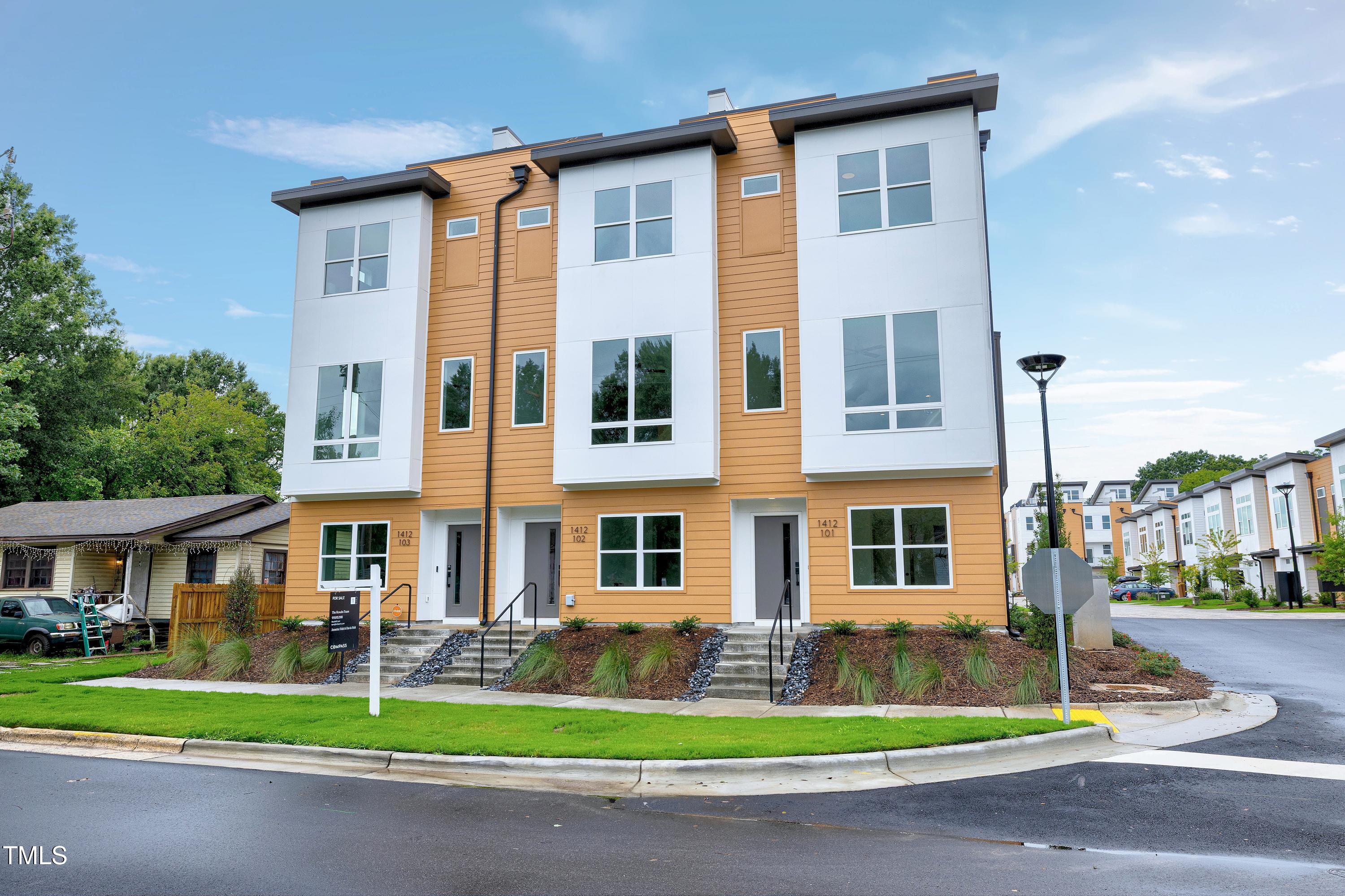 1412 Sawyer Road, Unit 101 Raleigh, NC 27610 - Photo 33 of 33 a front view of a residential apartment building with a yard and potted plants