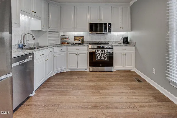 a kitchen with a refrigerator sink and cabinets