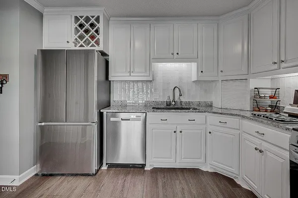 a kitchen with granite countertop white cabinets and stainless steel appliances