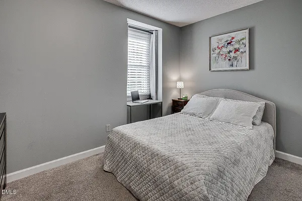 a bedroom with a bed and a painting on the wall