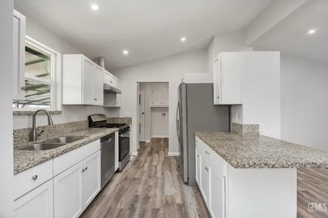 a kitchen with stainless steel appliances granite countertop a sink stove and refrigerator