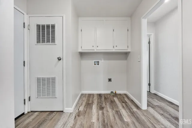 a view of empty room with wooden floor and cabinets