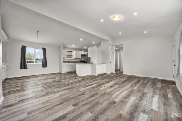 a view of an empty room and kitchen view