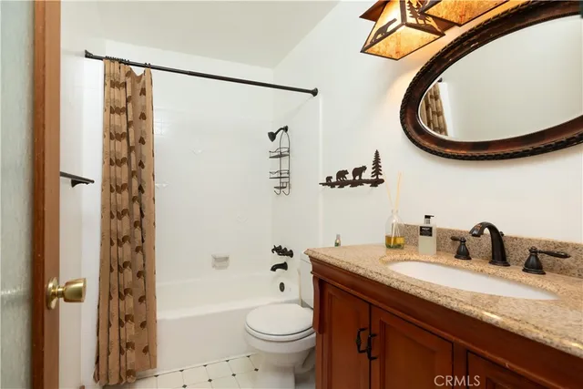 a bathroom with a granite countertop sink toilet and a mirror