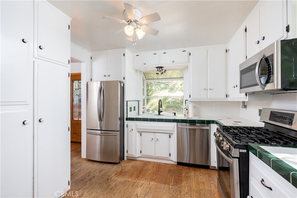 1268 Aleutian Drive Lake Arrowhead, CA 92352 - Photo 5 of 33 a kitchen with stainless steel appliances granite countertop a stove a refrigerator a microwave and cabinets