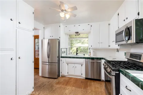a kitchen with stainless steel appliances granite countertop a stove a refrigerator a microwave and cabinets