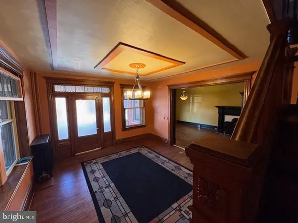 a view of an empty room with wooden floor and windows
