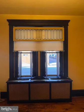 a view of an empty room with window and a bathroom