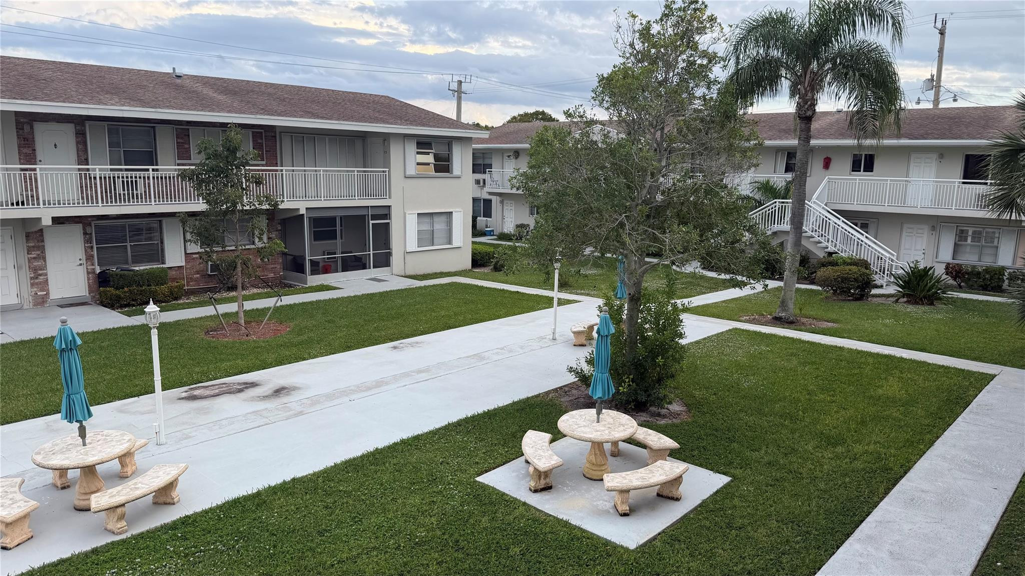 3850 Northeast 21st Way, Unit 62 Lighthouse Point, FL 33064 - Photo 11 of 13 a view of a white house with a yard table and chairs