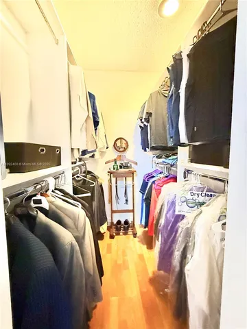 a view of walk in closet with clothes and shoes