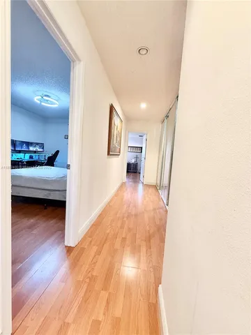 a view of a bedroom with a bed and wooden floor