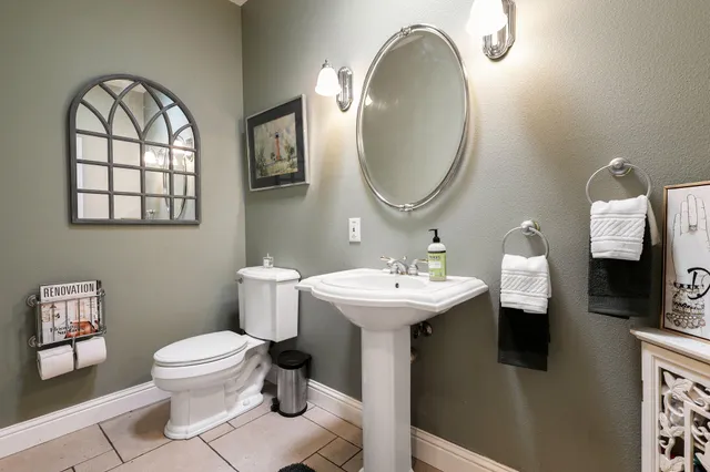 a bathroom with a toilet sink and mirror