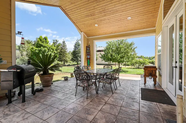 a view of a patio with table and chairs potted plants with wooden floor and fence