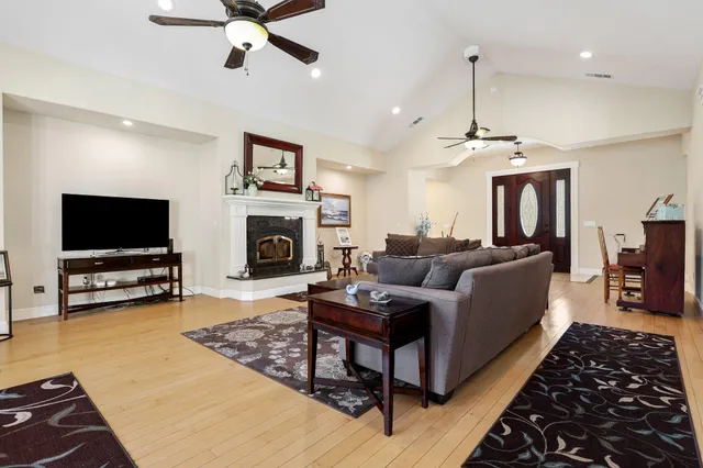 a living room with furniture a flat screen tv and a fireplace