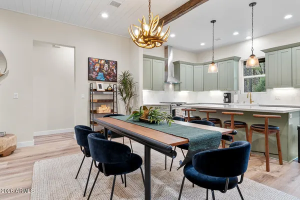 a kitchen with stainless steel appliances granite countertop a table chairs in it and wooden floors