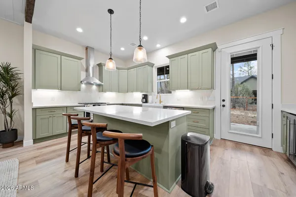 a metallic refrigerator freezer and a stove sitting inside of a kitchen