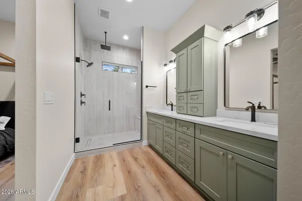 a view of an empty room with wooden floor and a ceiling fan