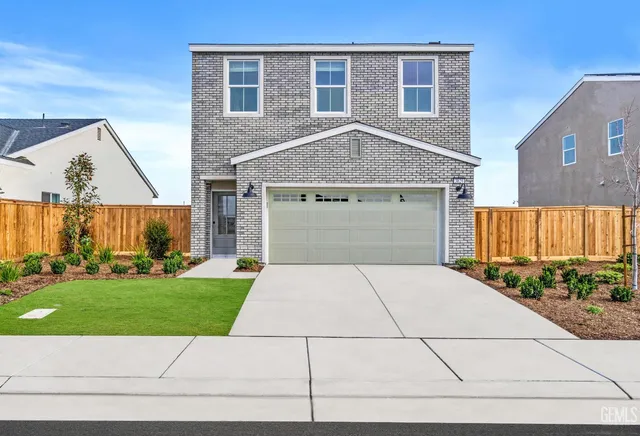 a front view of a house with a garden and a garage