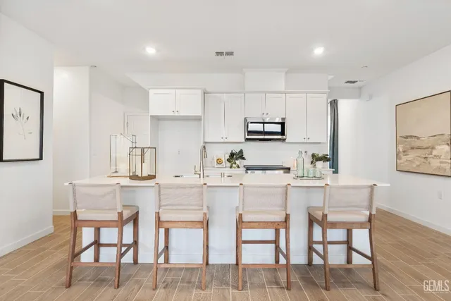 a kitchen with appliances cabinets and chair
