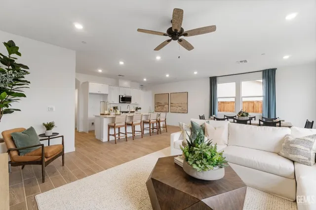 a living room with furniture kitchen and a chandelier