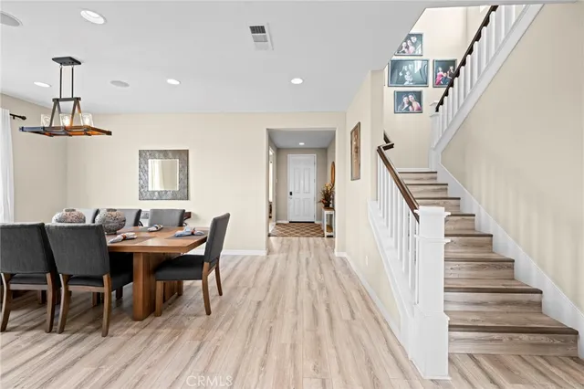 a view of staircase with lots of frames on wall and wooden floor