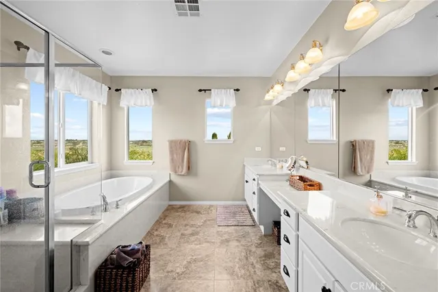 a spacious bathroom with a double vanity sink toilet mirror and shower