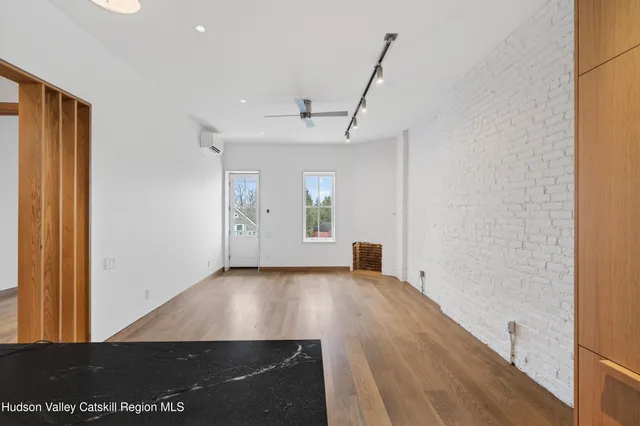 a view of a big room with wooden floor and windows
