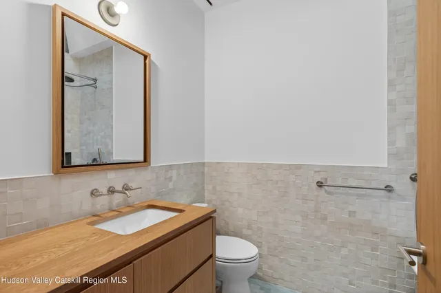 a bathroom with a granite countertop sink a toilet and a mirror
