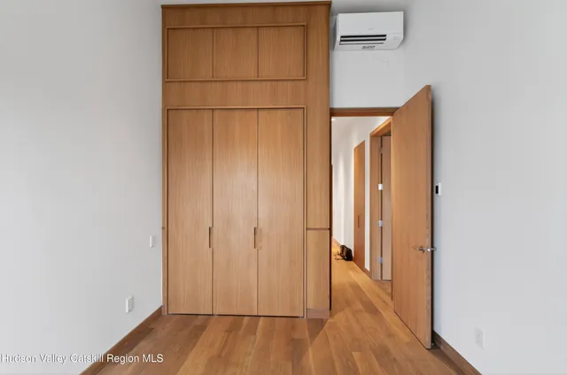 a view of a hallway with wooden floor and closet