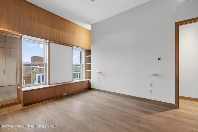 an empty room with wooden floor and windows
