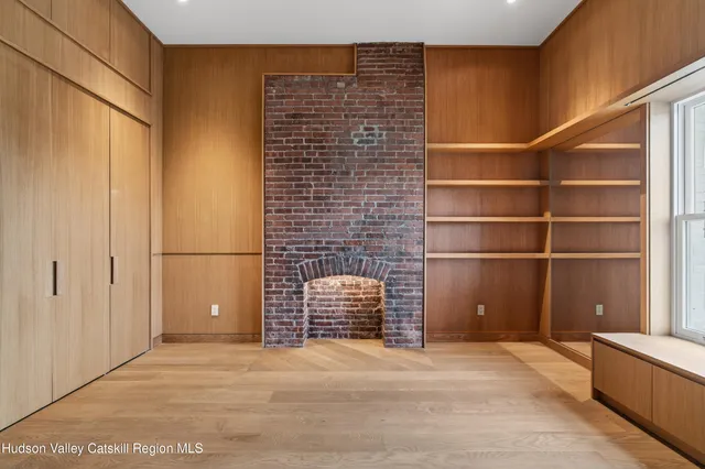 a view of an empty room with shelves and a window
