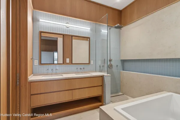 a bathroom with a tub a sink and a large mirror