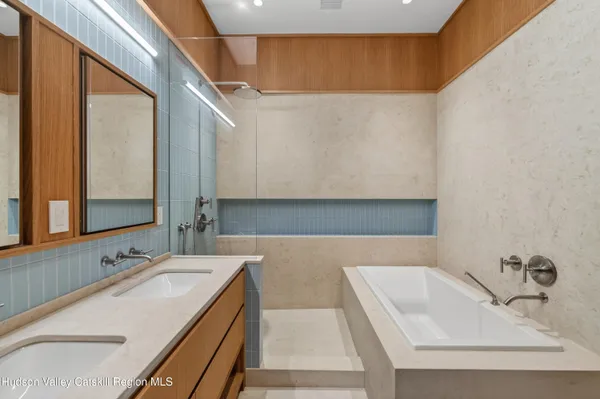 a bathroom with a tub sink and mirror