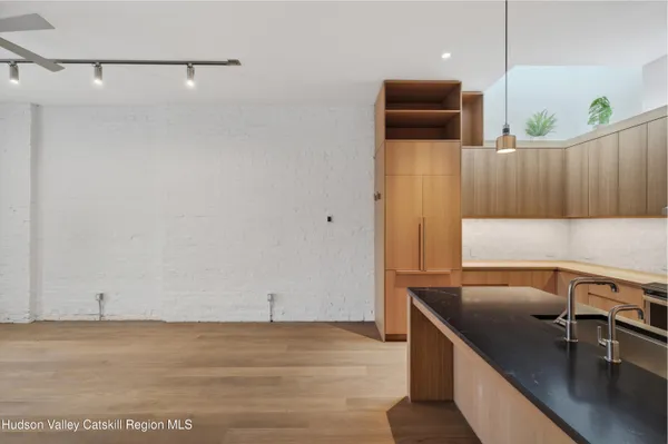 a view of a kitchen with a sink and wooden floor
