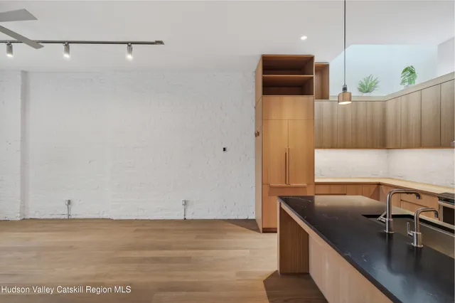 a view of a kitchen with a sink and wooden floor