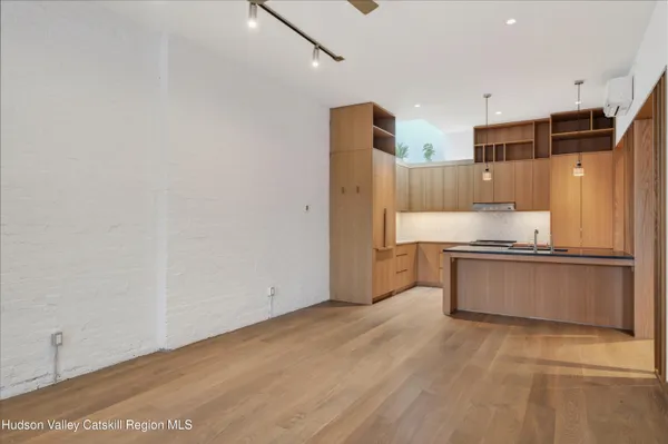 a large kitchen with a lot of counter space and wooden floor