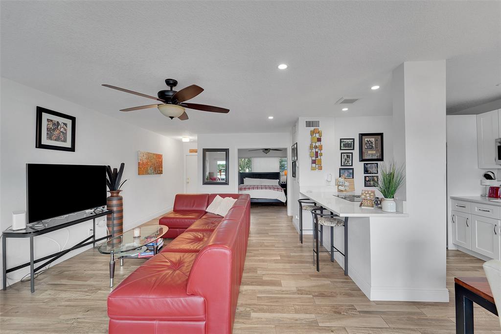 1201 South Riverside Drive, Unit 204 Pompano Beach, FL 33062 - Photo 12 of 48 a living room with furniture flat screen tv and wooden floor
